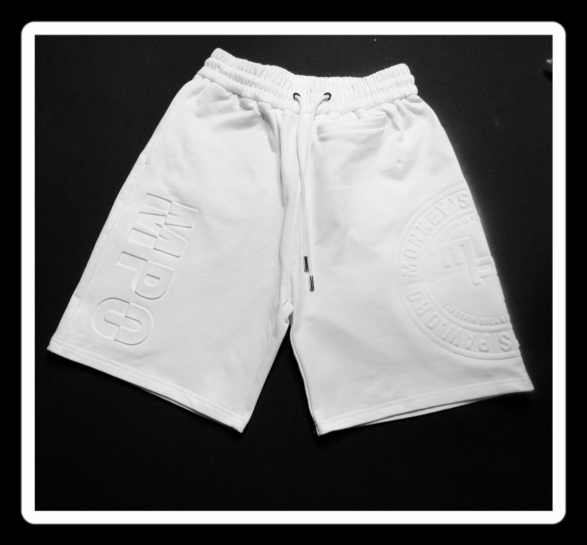 A pair of white shorts on a black background